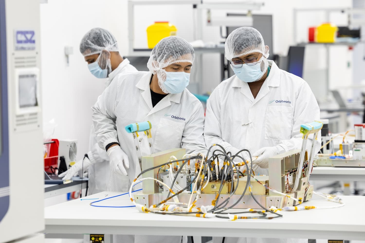 Engineers preparing spacecraft hardware in an Orbitworks controlled environment